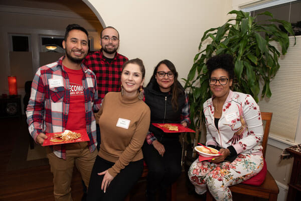 A small group of alumni pose for a photo during an event.