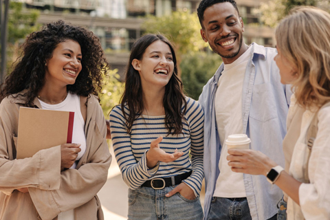 four people talking and smiling