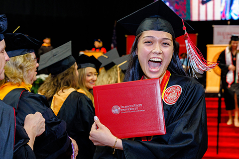 woman smiling holding up diploma