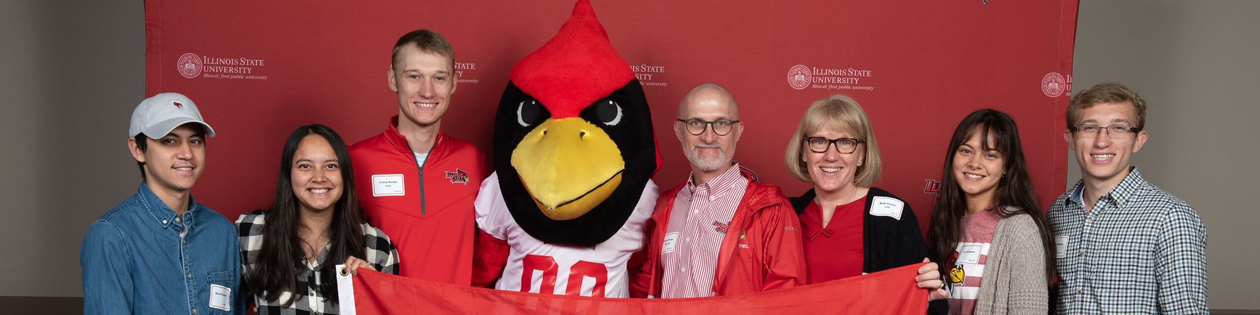 Family of ISU alumni pose with Reggie Redbird.