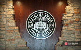 Desktop Thumbnail: University seal displayed over a wood and stone background